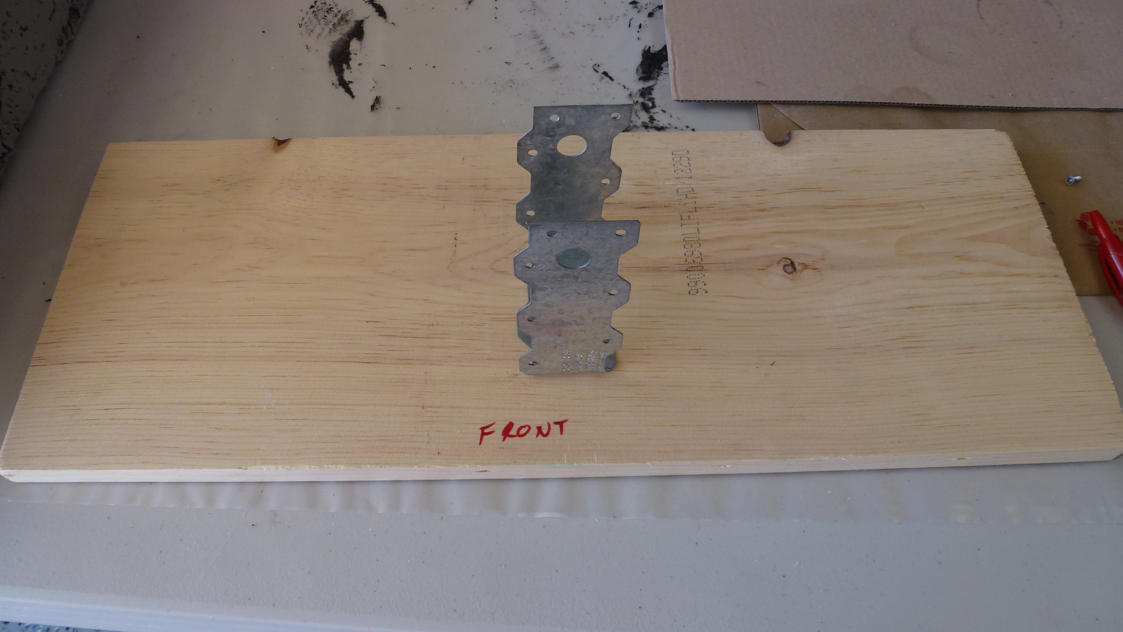 the U-bracket is secured to the base board with wood screws