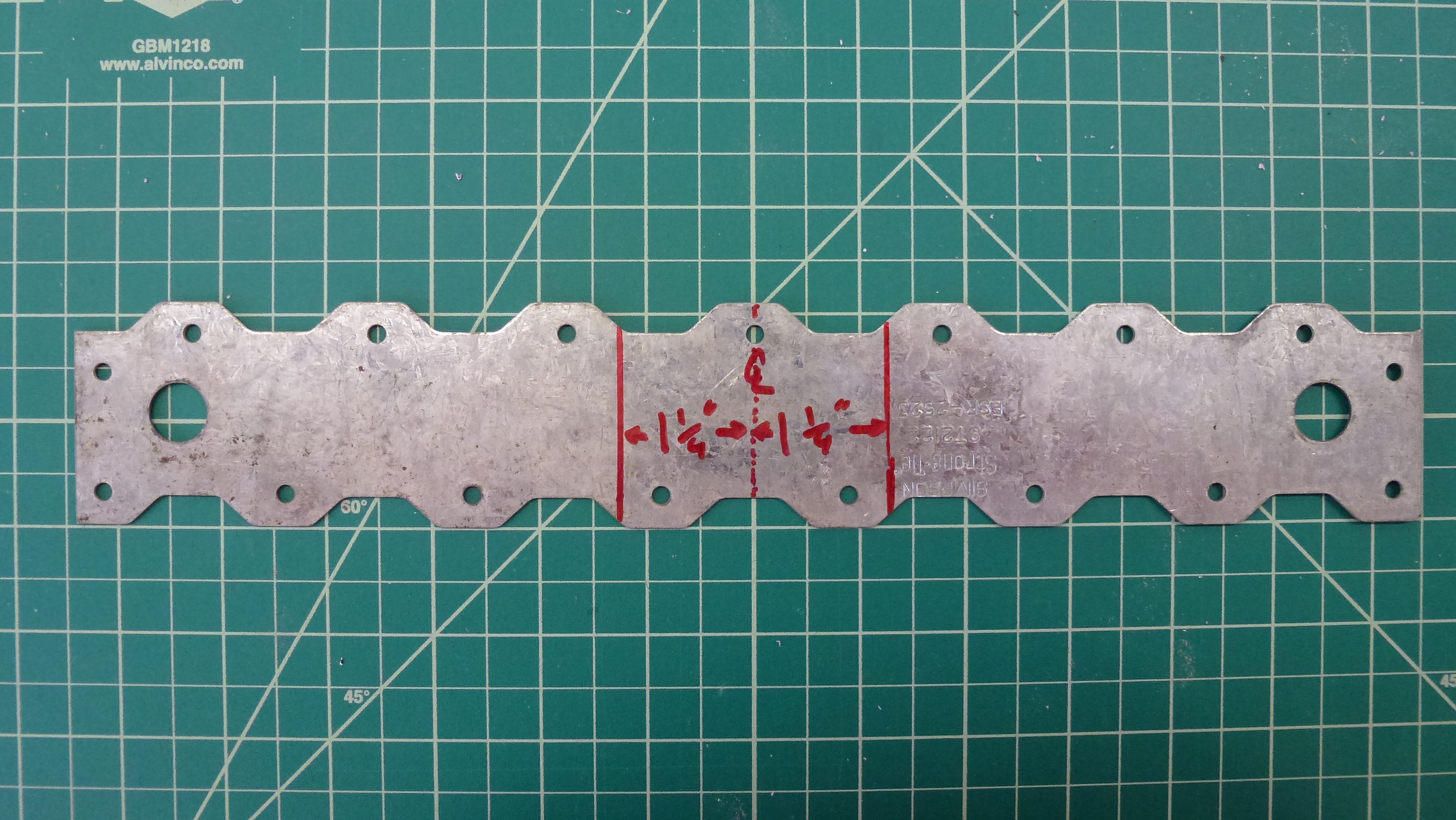 the wide strap tie is marked with the locations for bending it into the U-bracket