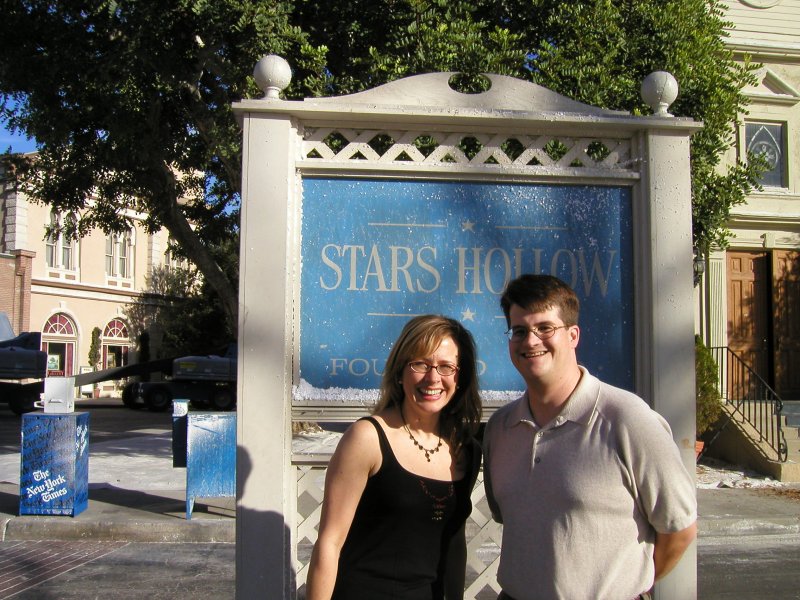 Sheila and Aid in front of the Stars Hollow sign and church