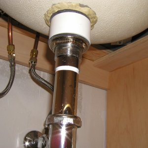 Photograph and entire assembly under the sink, with water dripping from the preassembled joint.
